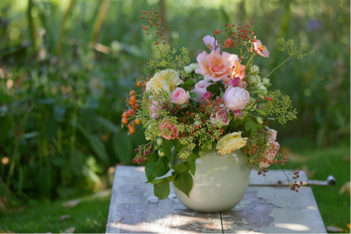 Egy szép, különféle virágokból készült herbárium áll egy kancsóban az asztalon.