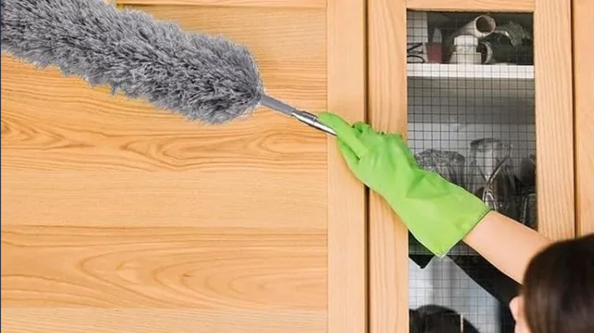 Ez a porsöprű még a magas plafonokról is letörli a port. 2 Egy lány port töröl egy seprűvel a szekrényről.