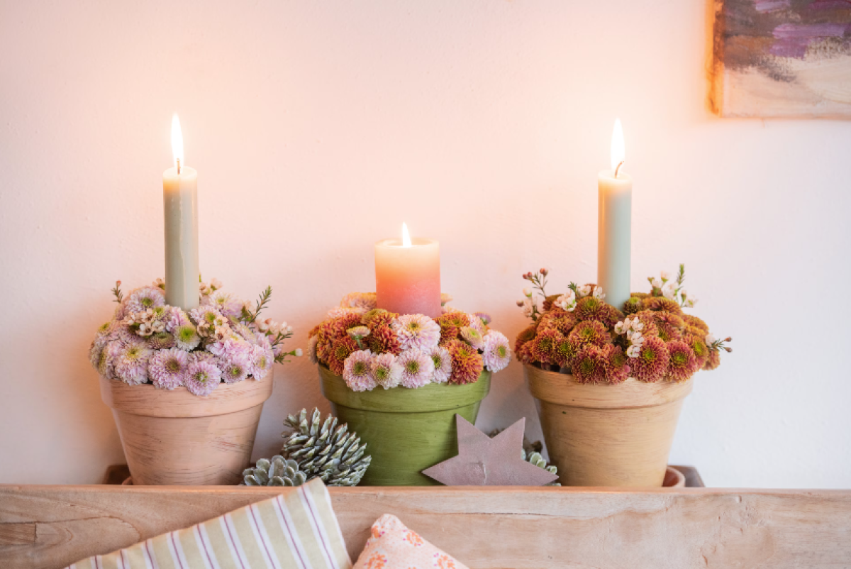 Három kézzel készített krizantém egy cserépben, gyertyával a belsejében — nagyon szépek.